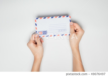 A female hand hold a envelope isolated white A female hand hold a envelope isolated white 49076497