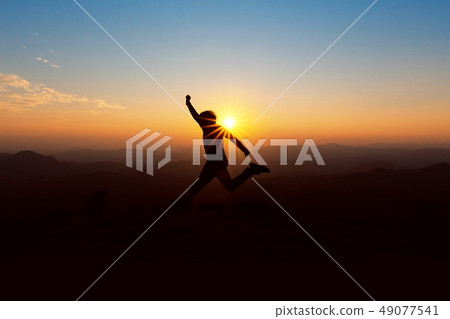 People jump on top of the mountain at sunset. People jump on top of the mountain at sunset. 49077541