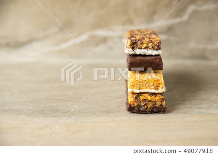 Various muesli bars on marble stone background 49077918