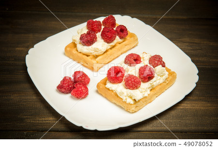 Sweet waffles with cream and fresh raspberries. Dessert Sweet waffles with cream and fresh raspberries. Dessert 49078052