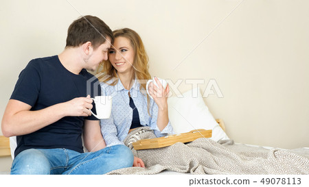 girl guy have breakfast in bed drink coffee talk smiling 49078113