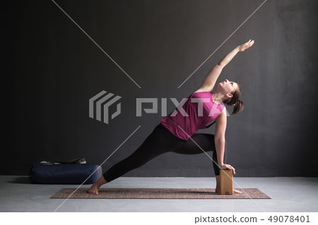 woman doing Extended Side Angle posture woman doing Extended Side Angle posture 49078401