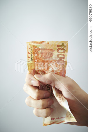 拿著澳門貨幣pataca的女性手 拿著澳門貨幣pataca的女性手 49079980