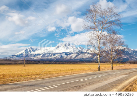 Road through the landscape with snowy mountains. Road through the landscape with snowy mountains. 49080286