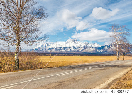 Road through the landscape with snowy mountains. Road through the landscape with snowy mountains. 49080287