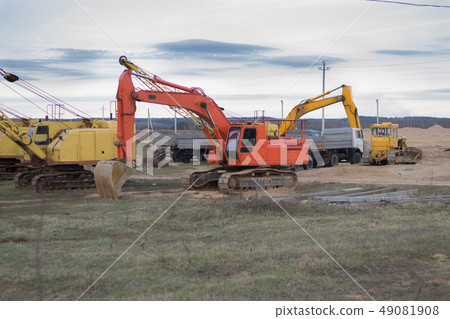 Excavator and trucks working on the excavation Excavator and trucks working on the excavation 49081908
