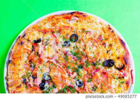 hot tasty fresh pizza on a plate close-up. green background hot tasty fresh pizza on a plate close-up. green background 49085277