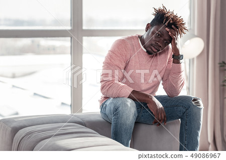 Tired male person sitting on cozy sofa 49086967