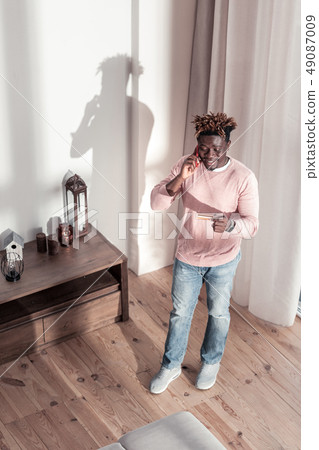 Kind brunette male person looking at his card Kind brunette male person looking at his card 49087009