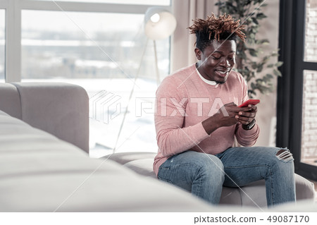 Positive delighted young freelancer enjoying online communication Positive delighted young freelancer enjoying online communication 49087170