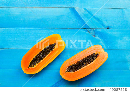 Papaya fruit on blue wooden background Papaya fruit on blue wooden background 49087238
