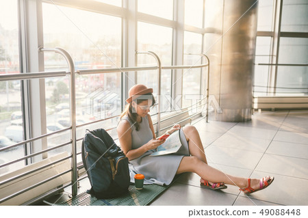 theme of tourism and travel of young student. Beautiful young caucasian girl in dress and hat sits 49088448