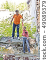 Father and son are playing through ruins 49089379