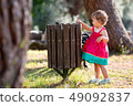 Sweet blond little baby girl throwing garbage into recycle bin 49092837