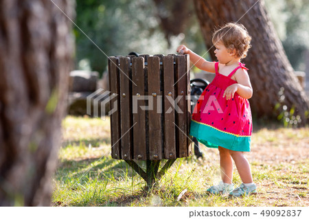 Sweet blond little baby girl throwing garbage into recycle bin Sweet blond little baby girl throwing garbage into recycle bin 49092837