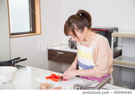 A woman cutting vegetables A woman cutting vegetables 49094690