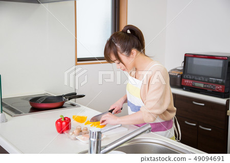 A woman cutting vegetables A woman cutting vegetables 49094691