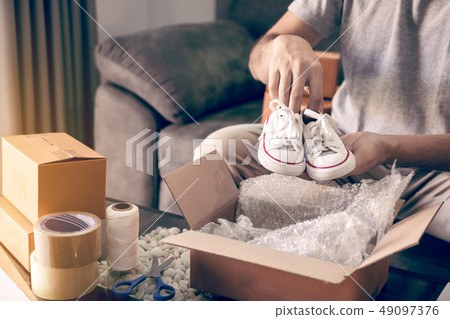 Asian entrepreneur teenager is carrying baby shoes Asian entrepreneur teenager is carrying baby shoes 49097376