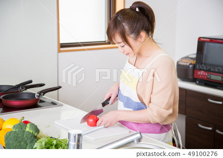 A woman cutting vegetables 49100276