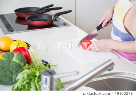 A woman cutting vegetables A woman cutting vegetables 49100278