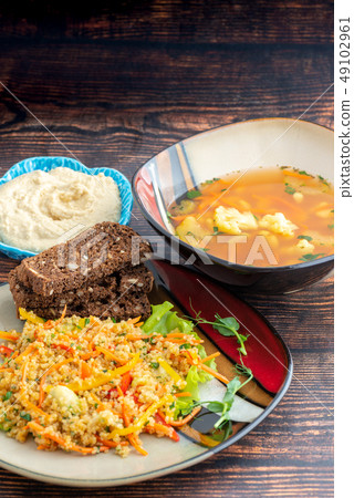 Coucous soup bread dinner on plates 49102961