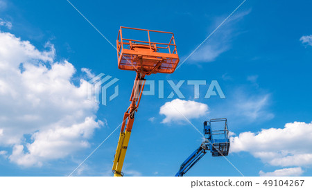 Cherry pickers on blue sky background 49104267