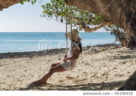 A woman who rides Taketomijima Kaiji beach swing 49106458