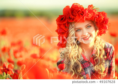 Portrait of a girl on the street with a wreath of poppy flowers on the head 49107628