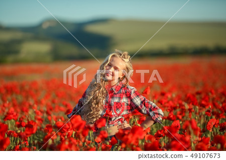 Portrait of a girl on the street with a wreath of poppy flowers on the head Portrait of a girl on the street with a wreath of poppy flowers on the head 49107673