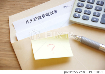 Receipt of hospital medical expenses in an envelope and a sticky note with a calculator and pen and an ending mark written on it Receipt of hospital medical expenses in an envelope and a sticky note with a calculator and pen and an ending mark written on it 49109049