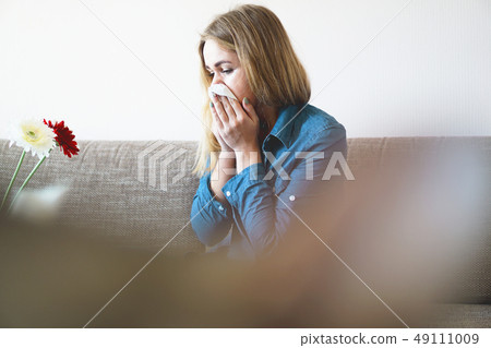 Spring cold or allergies. Attractive girl is allergic to flowers, uses a napkin 49111009