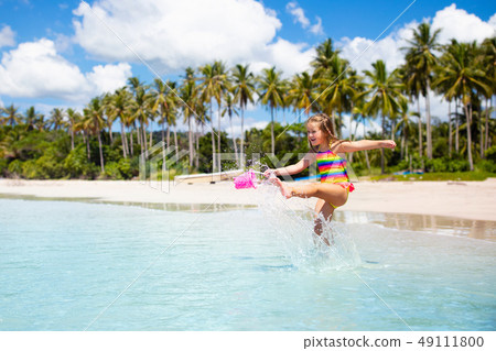 Kids play on tropical beach. Sand and water toy. 49111800