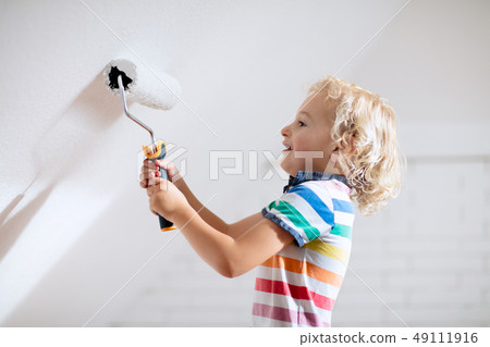 Kids painting attic wall. Home improvement. Kids painting attic wall. Home improvement. 49111916
