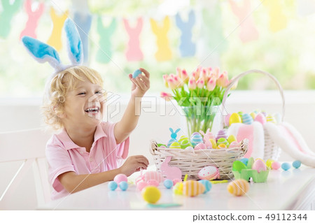 Kids on Easter egg hunt. Children dye eggs. 49112344