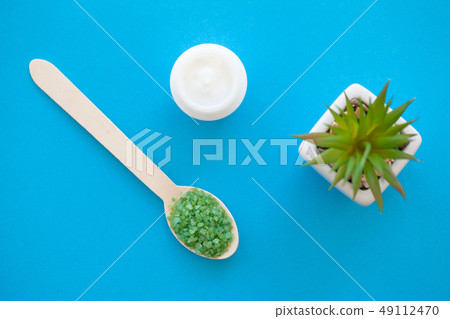 Spa. Green sea salt in wooden spoons on a white background with a space for a text. Spa. Green sea salt in wooden spoons on a white background with a space for a text. 49112470
