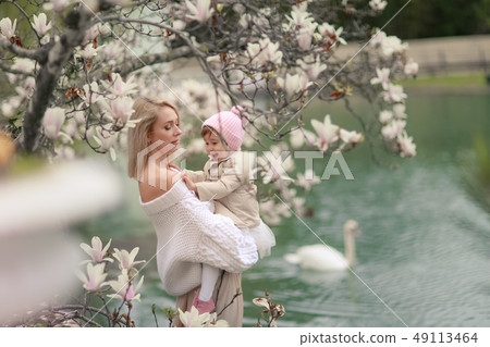 Happy family on a summer meadow. little girl child baby daughter hugging and kissing mother Happy family on a summer meadow. little girl child baby daughter hugging and kissing mother 49113464