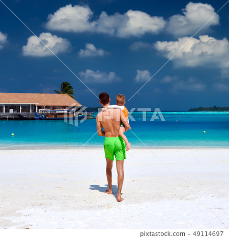 Toddler boy on beach with father Toddler boy on beach with father 49114697