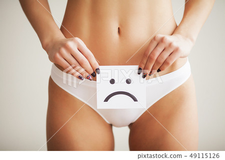 Woman Health Problem. Closeup Of Female With Fit Slim Body In Panties Holding White Card With Sad 49115126