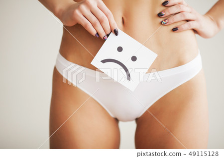 Woman Health Problem. Closeup Of Female With Fit Slim Body In Panties Holding White Card With Sad 49115128