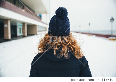 Rear view young woman with curly red hair Rear view young woman with curly red hair 49115610