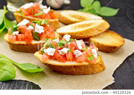 Bruschetta with tomato and cheese on dark board 49120326