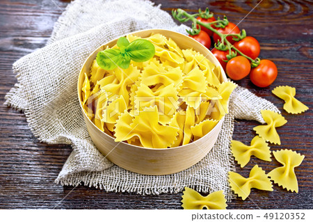 Farfalle in bark box with basil on board 49120352