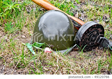 Helmet and submachine gun with tulip on grass Helmet and submachine gun with tulip on grass 49120766