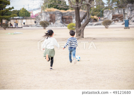 kid playing soccer in the park kid playing soccer in the park 49121680