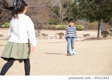kid playing soccer in the park 49121681