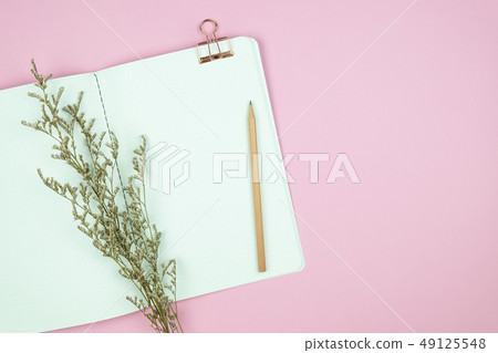 Top view of notebook pencil and flower on pink 49125548