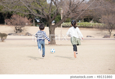 kid playing soccer in the park 49131860
