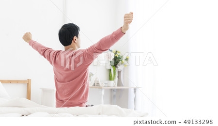 man wake up and stretching arms near window  49133298
