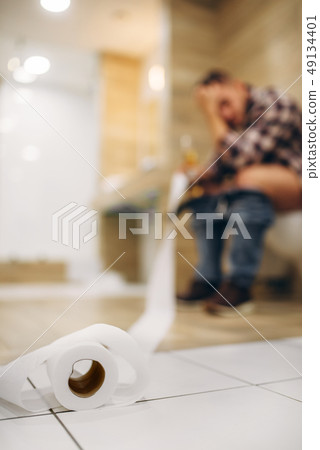 Sad man with hangover sitting on toilet 49134401