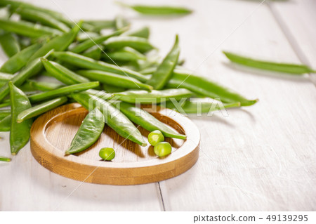 Green sugar snap pea on grey wood 49139295